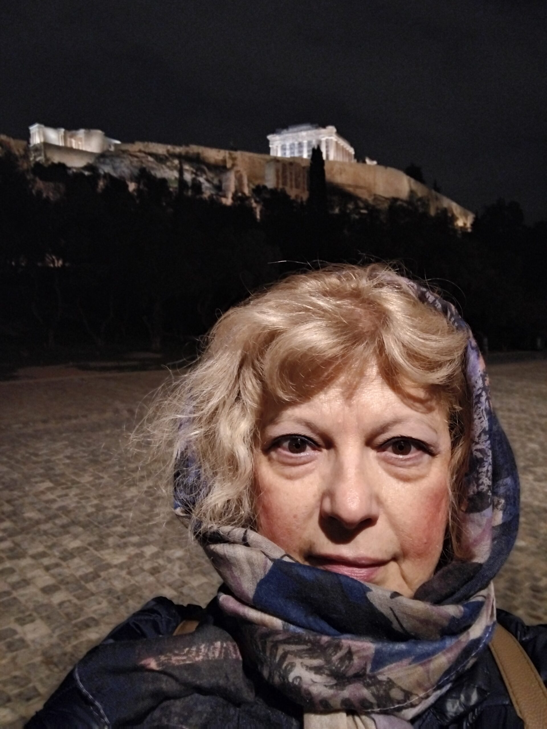 Απεικονίζεται η συγγραφέας Μαρία Μπούκλα μπροστά από τον βράχο της Ακρόπολης